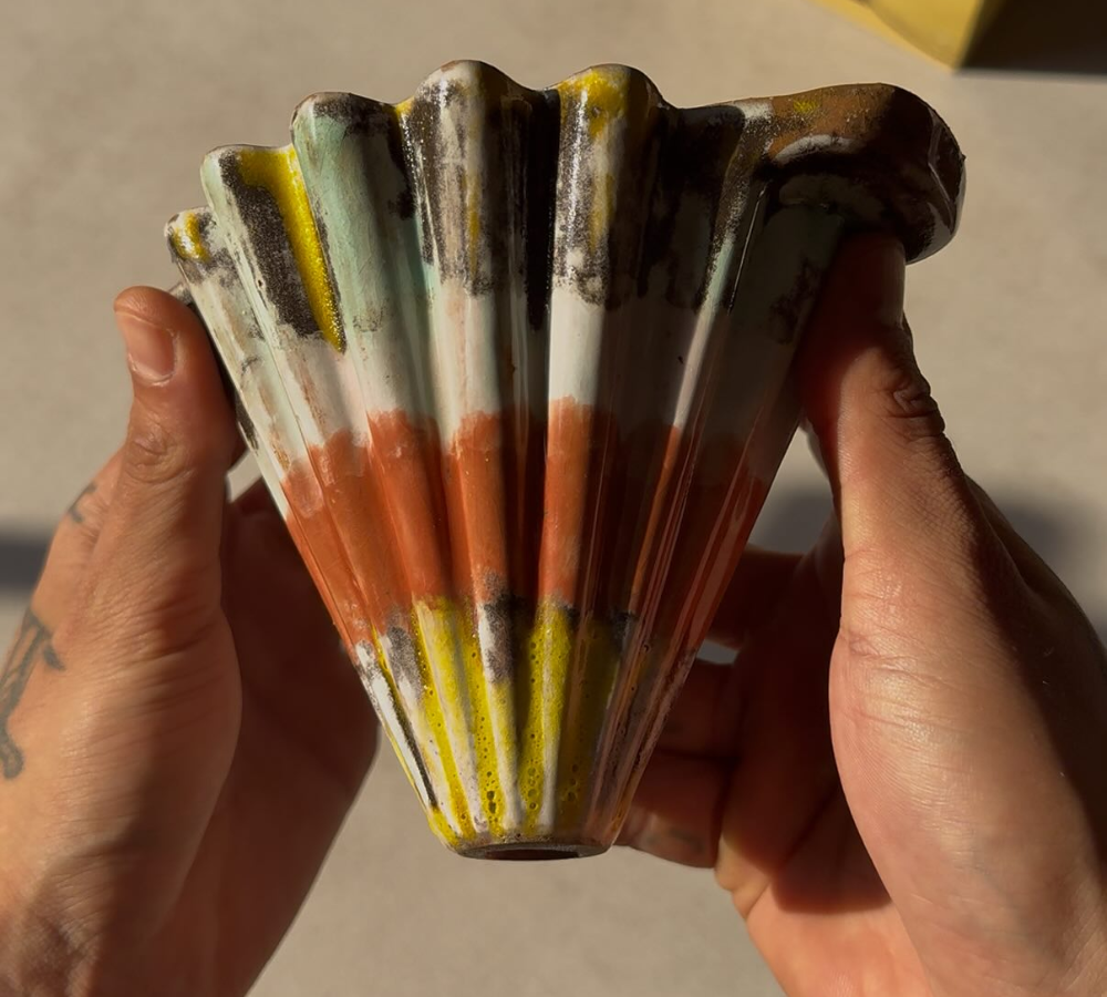 Coador cerâmico artesanal colorido feito à mão segurado pelas mãos